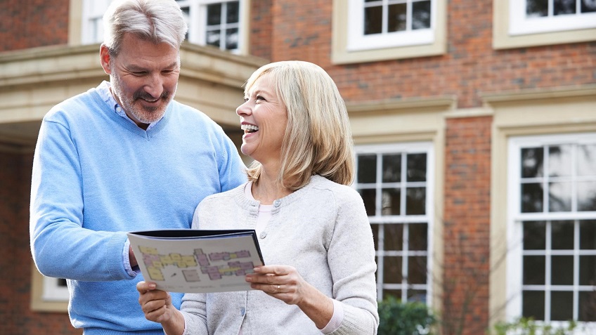 Couple outside of house holding property sales details