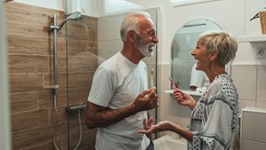 Smiling older couple standing in their bathroom