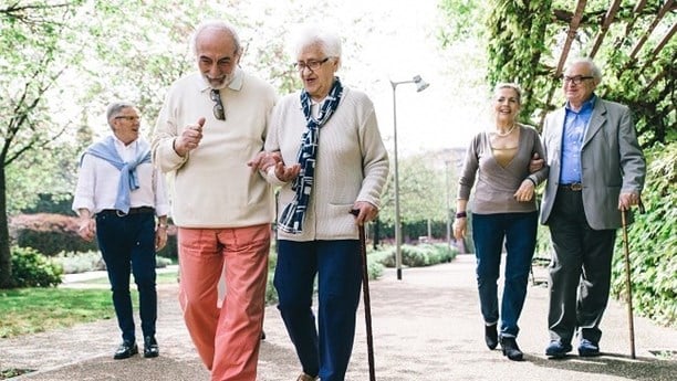 Group of older people walking in a garden