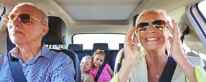Senior couple in car with granchildren