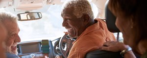 Group of senior friends enjoying road trip in car together