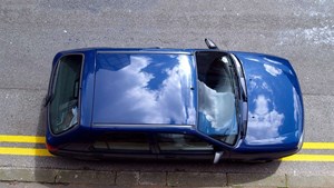 Blue car illegally parked on double yellow lines