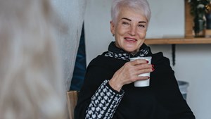 An older woman socialising in winter with friend.