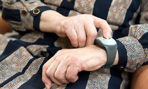Close up of hands with personal alarm worn on wrist