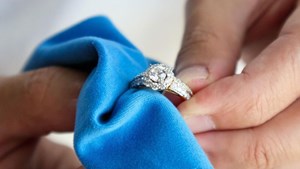 Diamond ring being polished with blue cloth