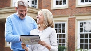 Couple outside of house holding property sales details