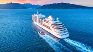 Cruise ship at sea heading to land at sunset