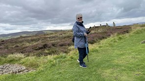 an elderly lady with a walking stick in scottish nature