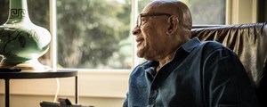 Man at home looking out of window
