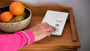 older person calling for help using a personal alarm