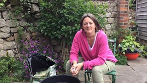 gardening expert alex mitchell sits down in front of a compost barrel