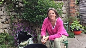 gardening expert alex mitchell sits down in front of a compost barrel